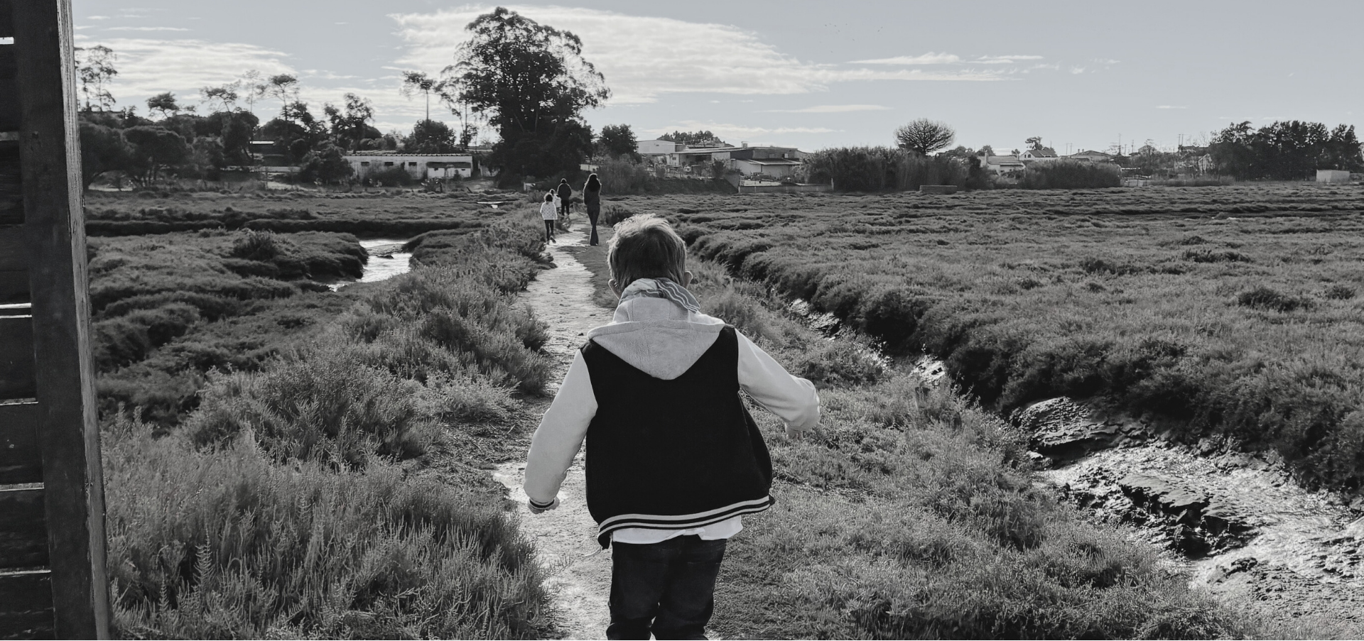 Joyful boy running through a vibrant wildflower meadow, evoking carefree childhood and Little Battersea's commitment to nature-inspired organic essentials