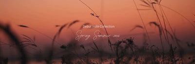 Cinematic hero video preview of the SS26 Riviera Arrábida collection — organic muslin swaddles and lightweight textiles drifting on a sunlit Portuguese beach.